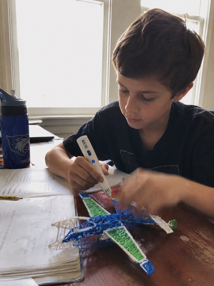 Une enfant utilise le stylo 3D Pen'Up 3D et montre fièrement sa création